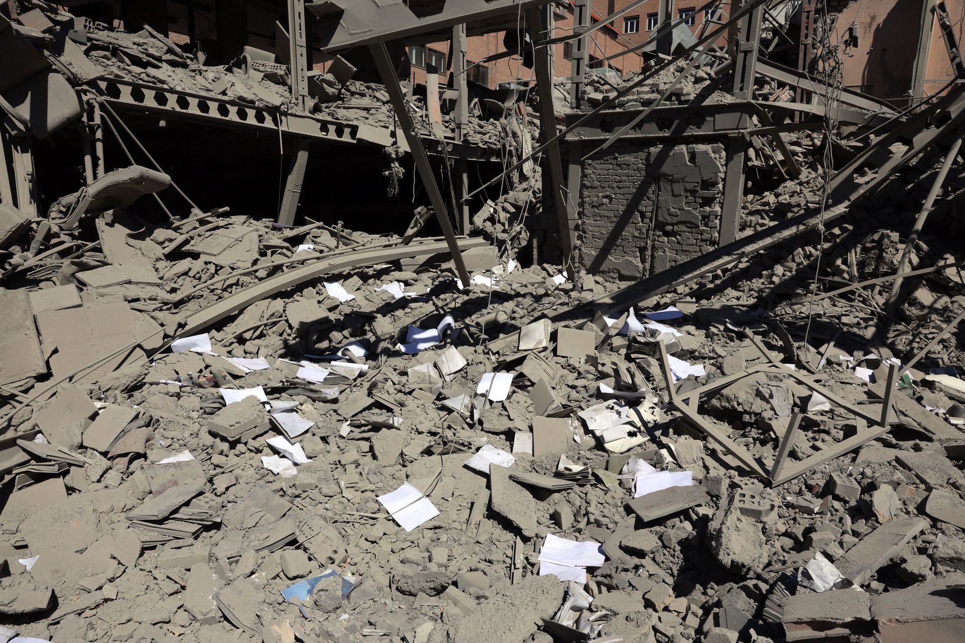 Papieren liggen op het puin van een beschadigd gebouw aan de Sharif-universiteit na een luchtaanval in Teheran, Iran, 7 april 2026.